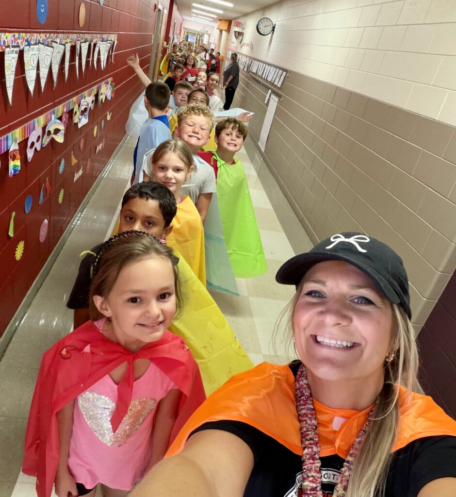 Teacher leading her superhero class down the hall.